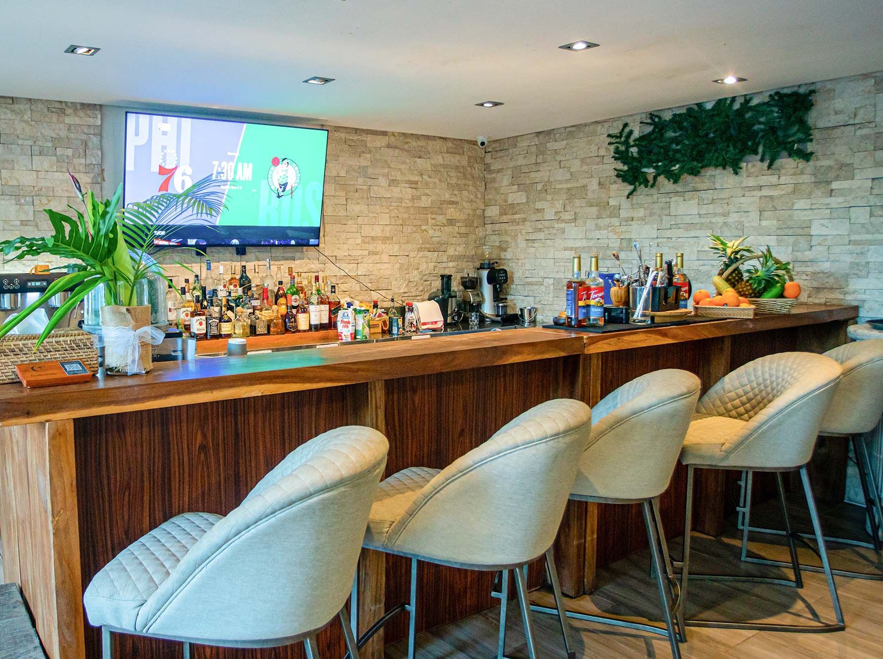 A bar with chairs and a television on the wall in El Nido Palawan resorts