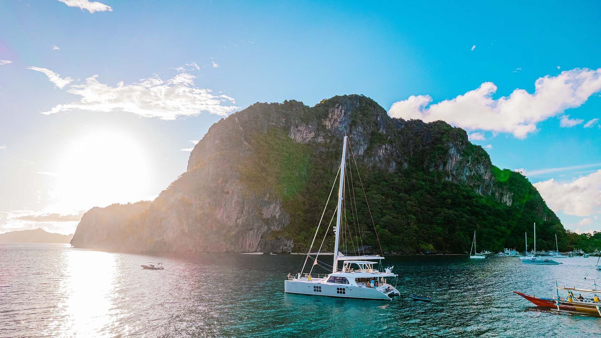 A sailboat is floating in the water near a small island in Palawan