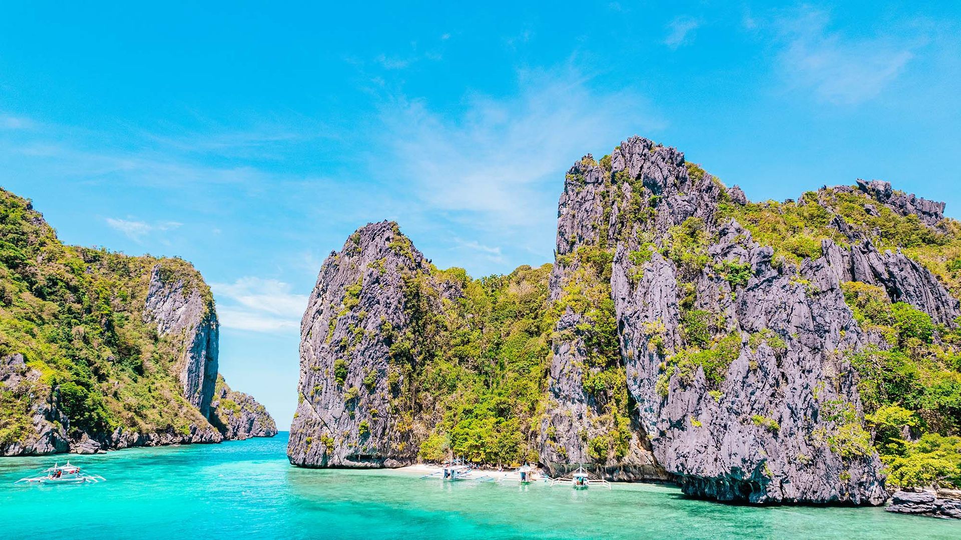 Rocky islands with lush green vegetation, turquoise water, and blue sky.