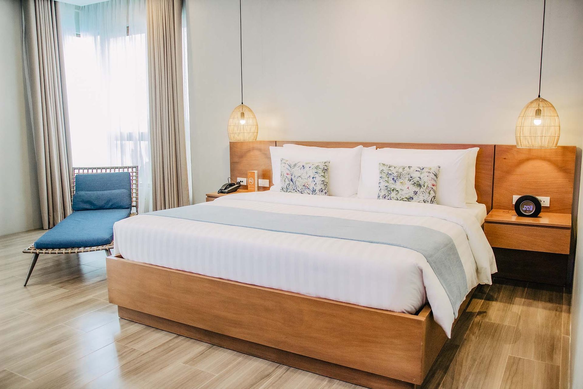 A hotel room with a large bed and a blue chair in El Nido Palawan resorts