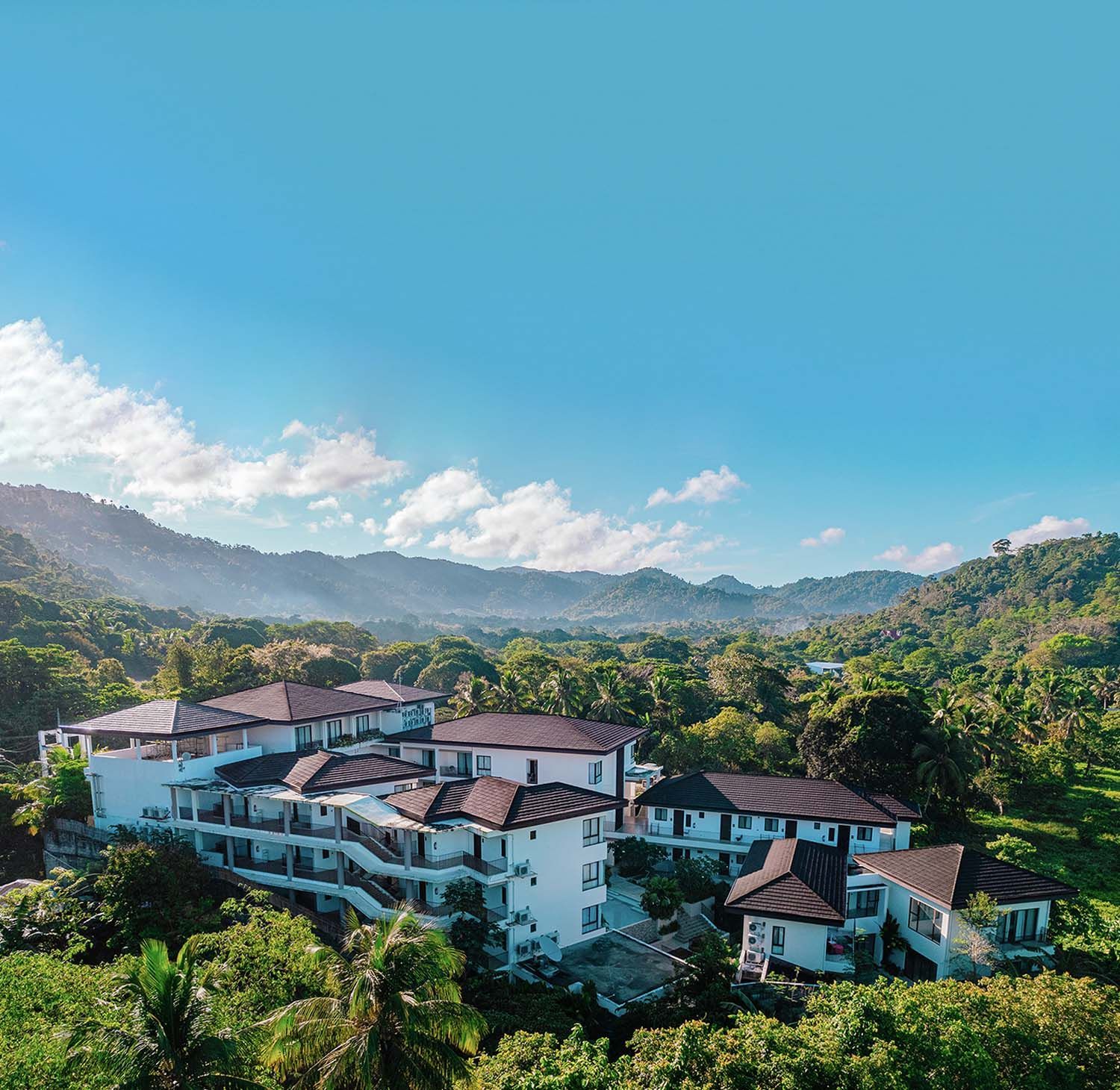 Best resorts in El Nido Palawan nestled in a lush, green valley under a bright blue sky.