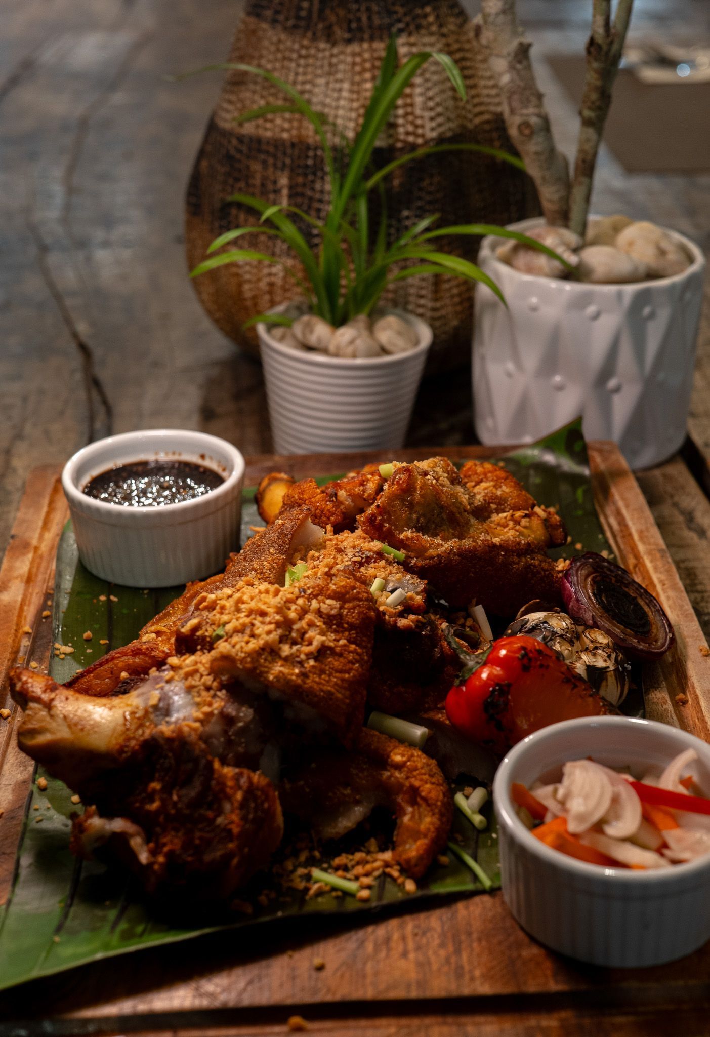 Fried chicken with sauce and pickled vegetables on a wooden board.