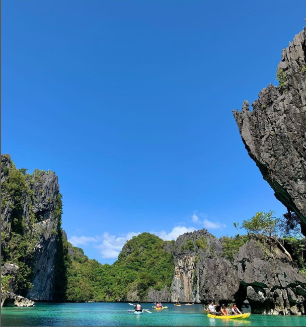 Family with a young child swimming together in the outdoor pool at Charlie's El Nido