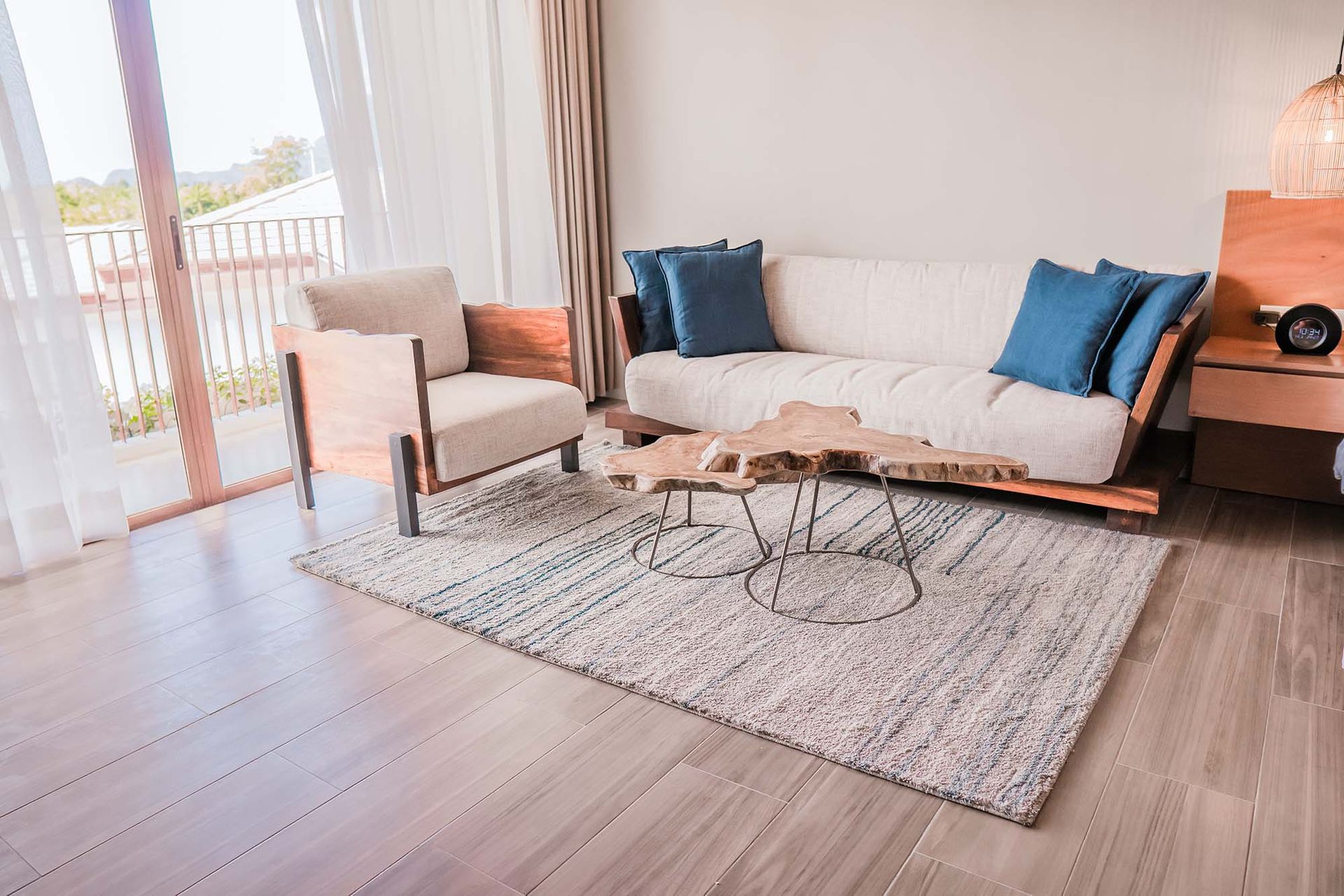 Living room with a beige sofa, armchair, and wooden coffee table on a rug.