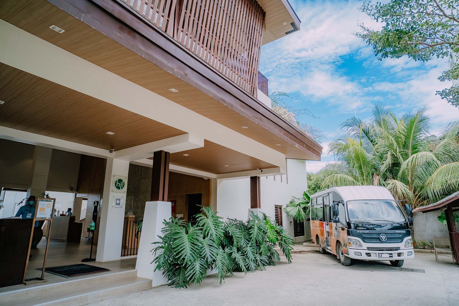A white van is parked in front of a Charlie El Nido