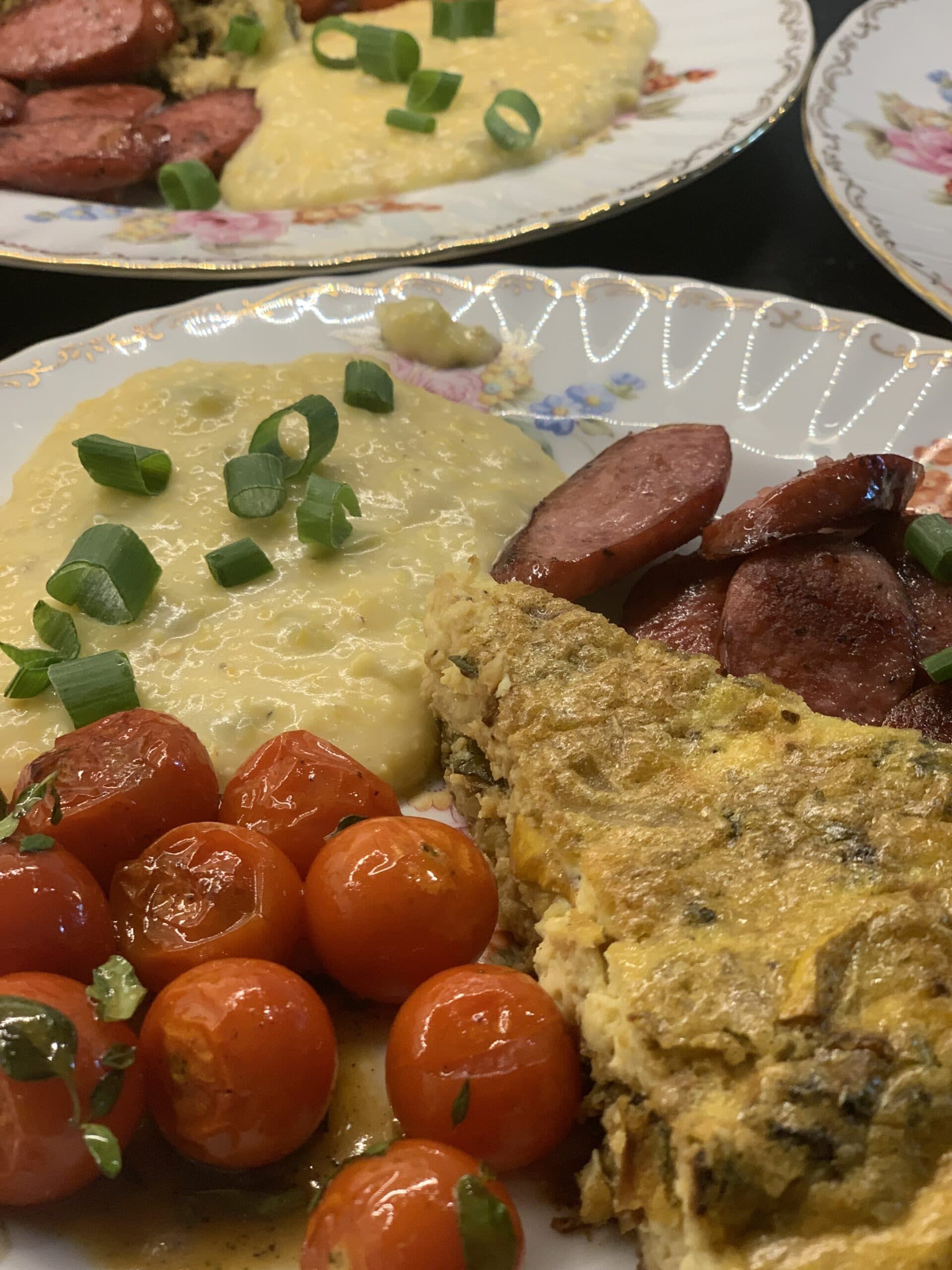 A plate of food with tomatoes and sausage on it