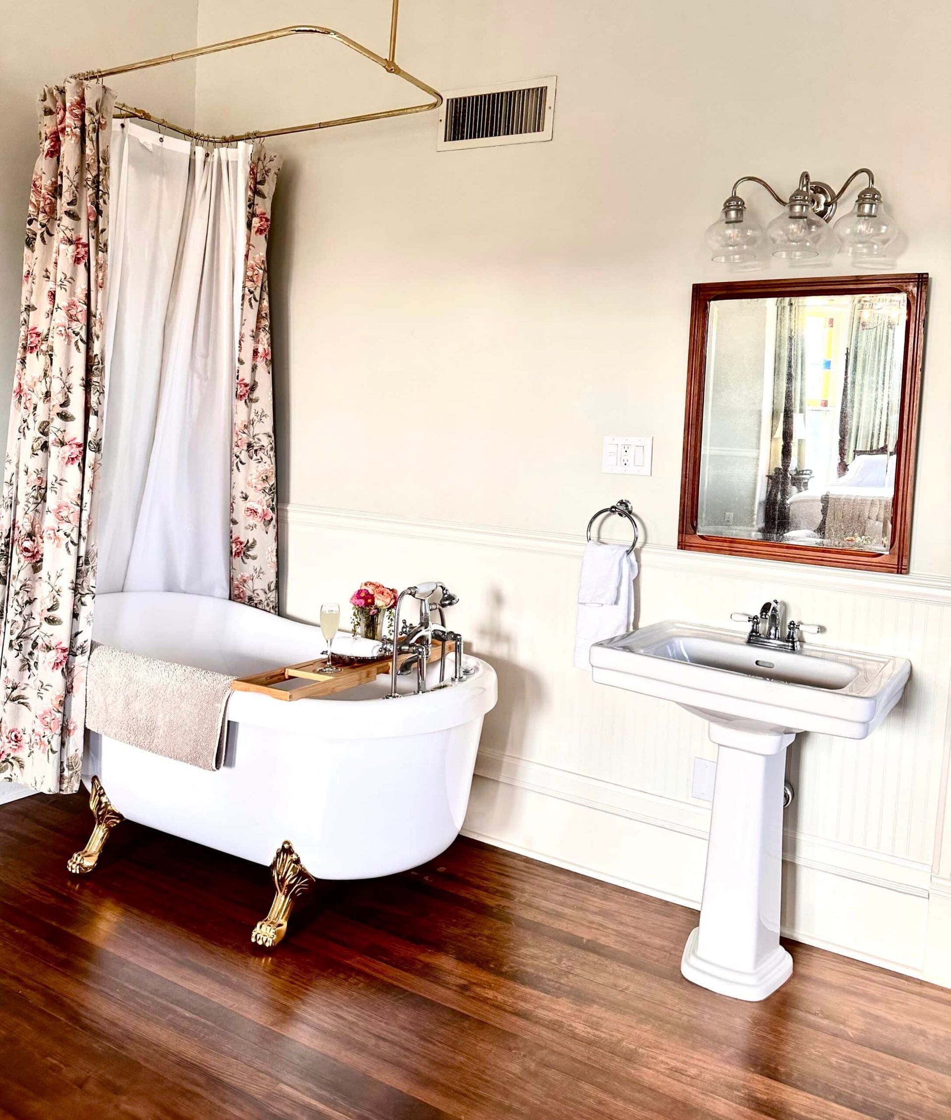 A bathroom with a bathtub , sink , mirror and shower curtain.
