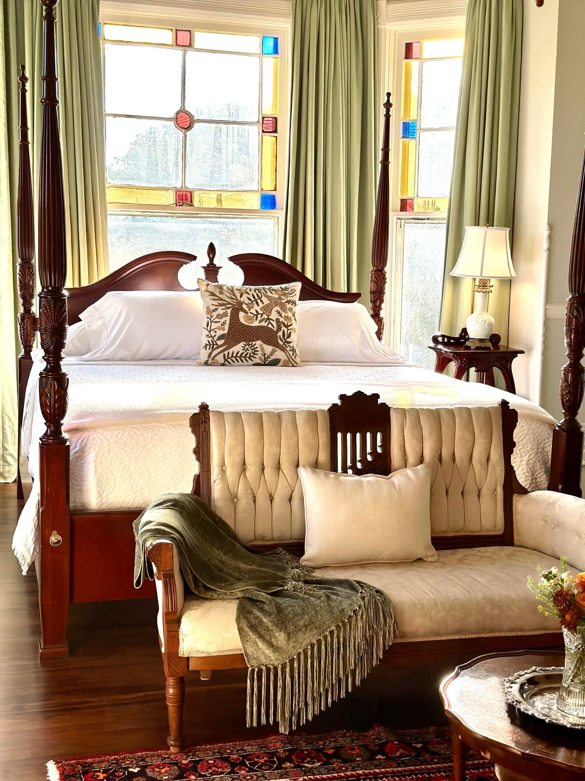 A bedroom with a four poster bed and a couch