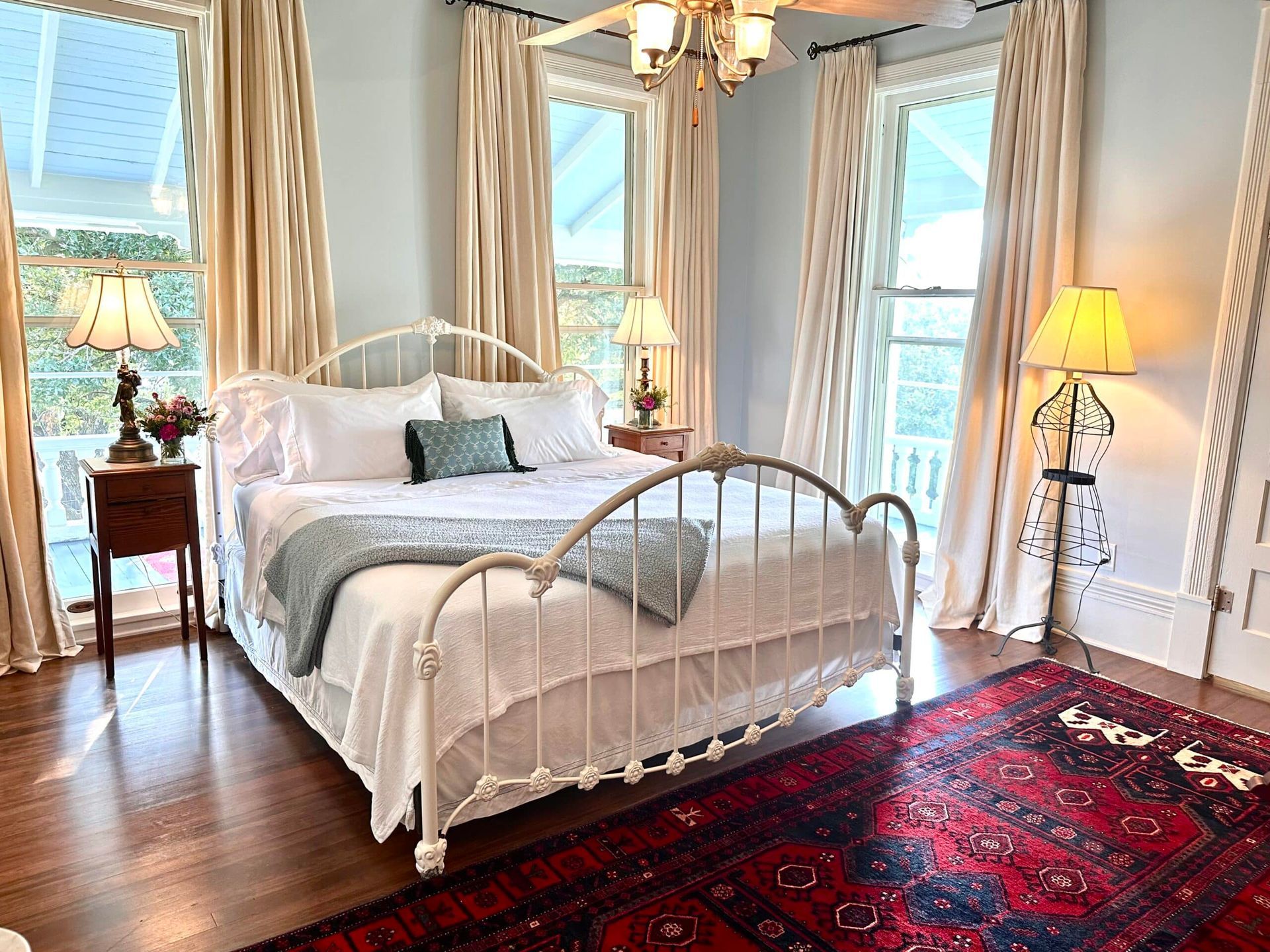 A bedroom with a bed , lamps , and a rug.