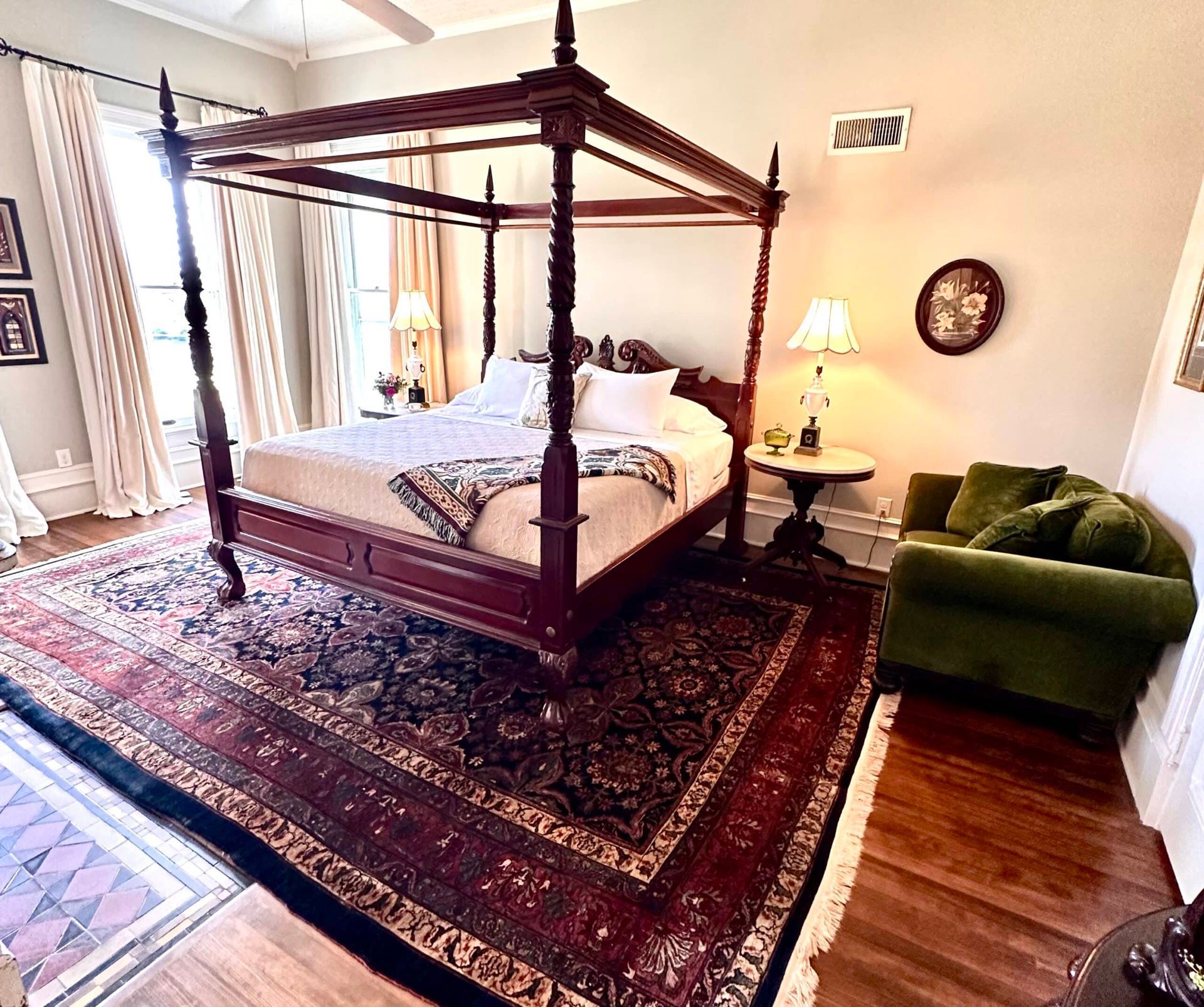 A bedroom with a four poster bed and a rug.