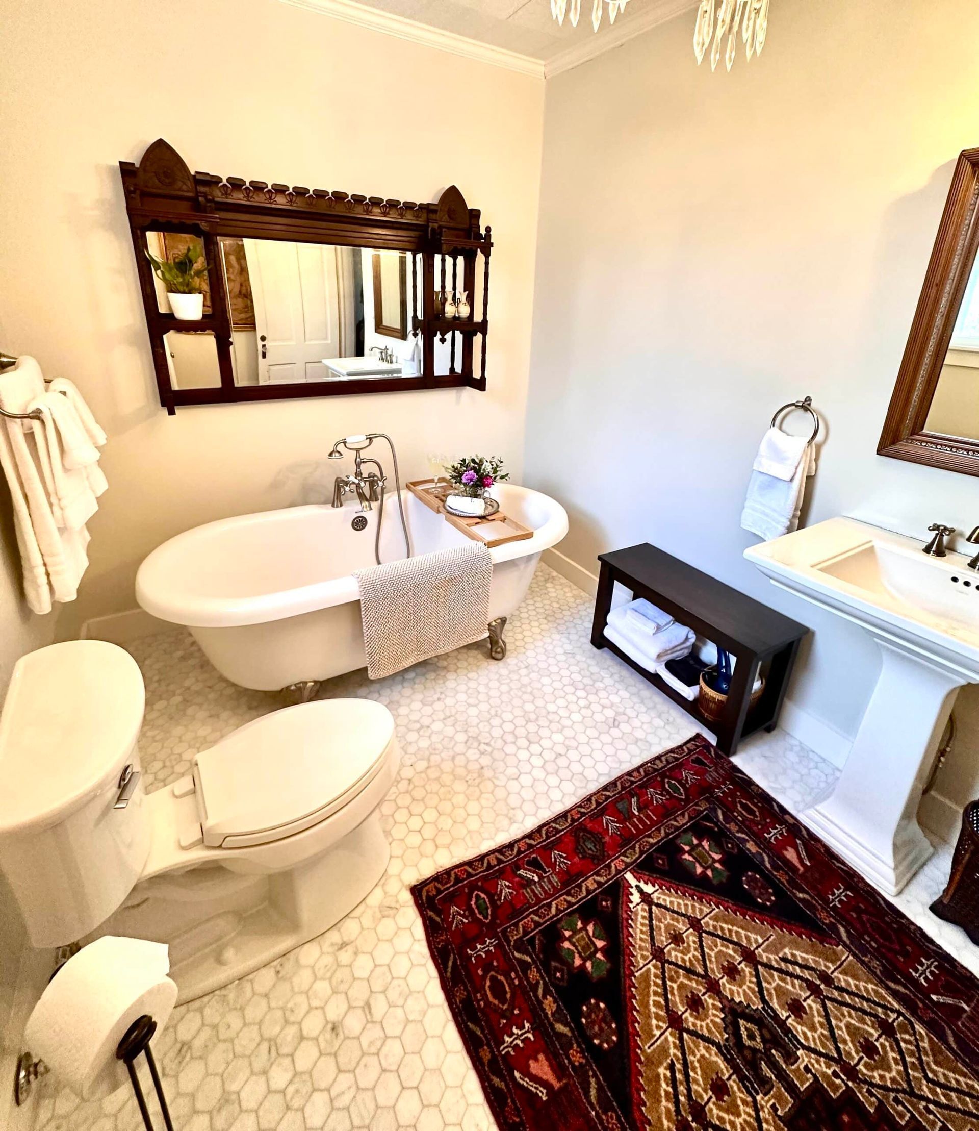 A bathroom with a tub , toilet , sink and mirror.