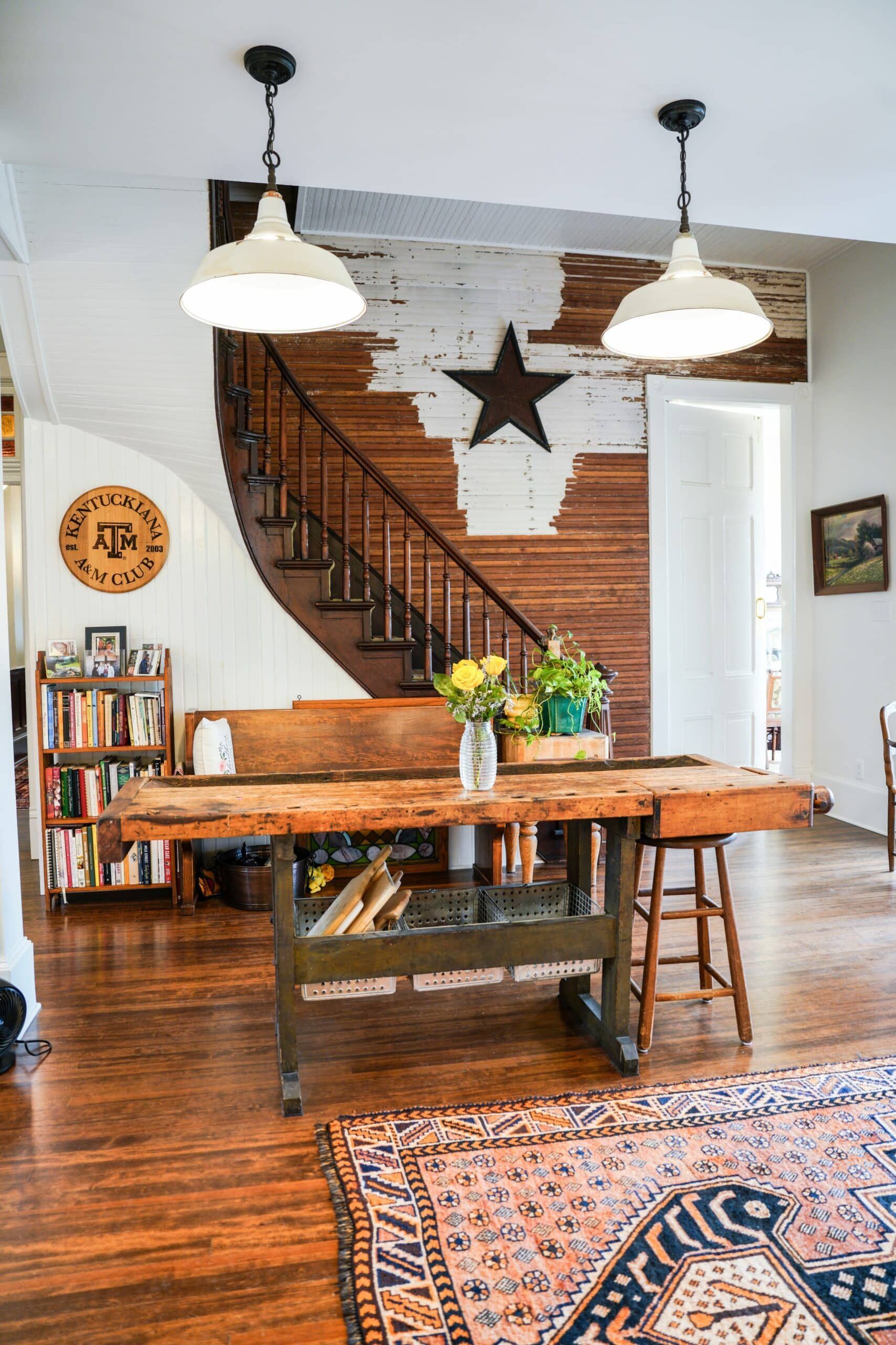 A living room with a wooden table and stairs.