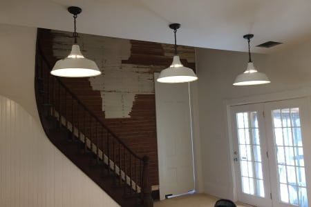 A staircase with three lights hanging from the ceiling