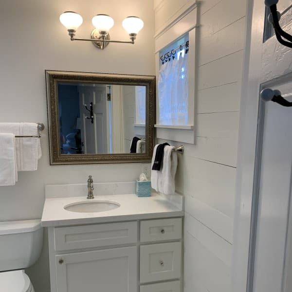 A bathroom with a toilet a sink and a mirror