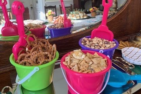 A table topped with buckets filled with snacks and spoons.