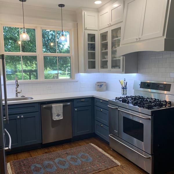 A kitchen with stainless steel appliances and blue cabinets