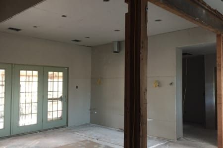 A room with a lot of windows and a ceiling that is being remodeled.