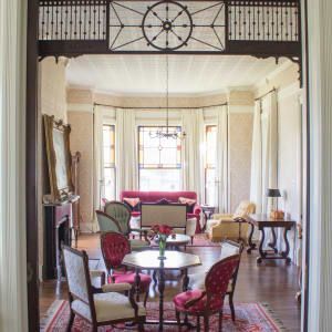 A living room with a couch , chairs , tables and a fireplace.