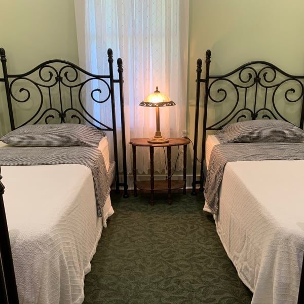 A bedroom with two twin beds and a lamp
