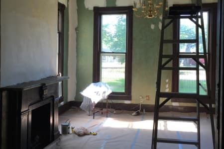 A room with a fireplace and a ladder in it