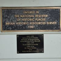 A plaque on a wall that says `` entered in the national register of historic places bryan historic resources survey 1987 ''.
