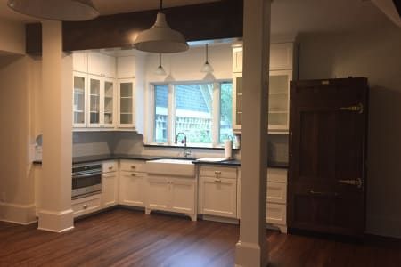 An empty kitchen with white cabinets and black counter tops