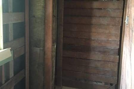 A wooden door in a room with a window.
