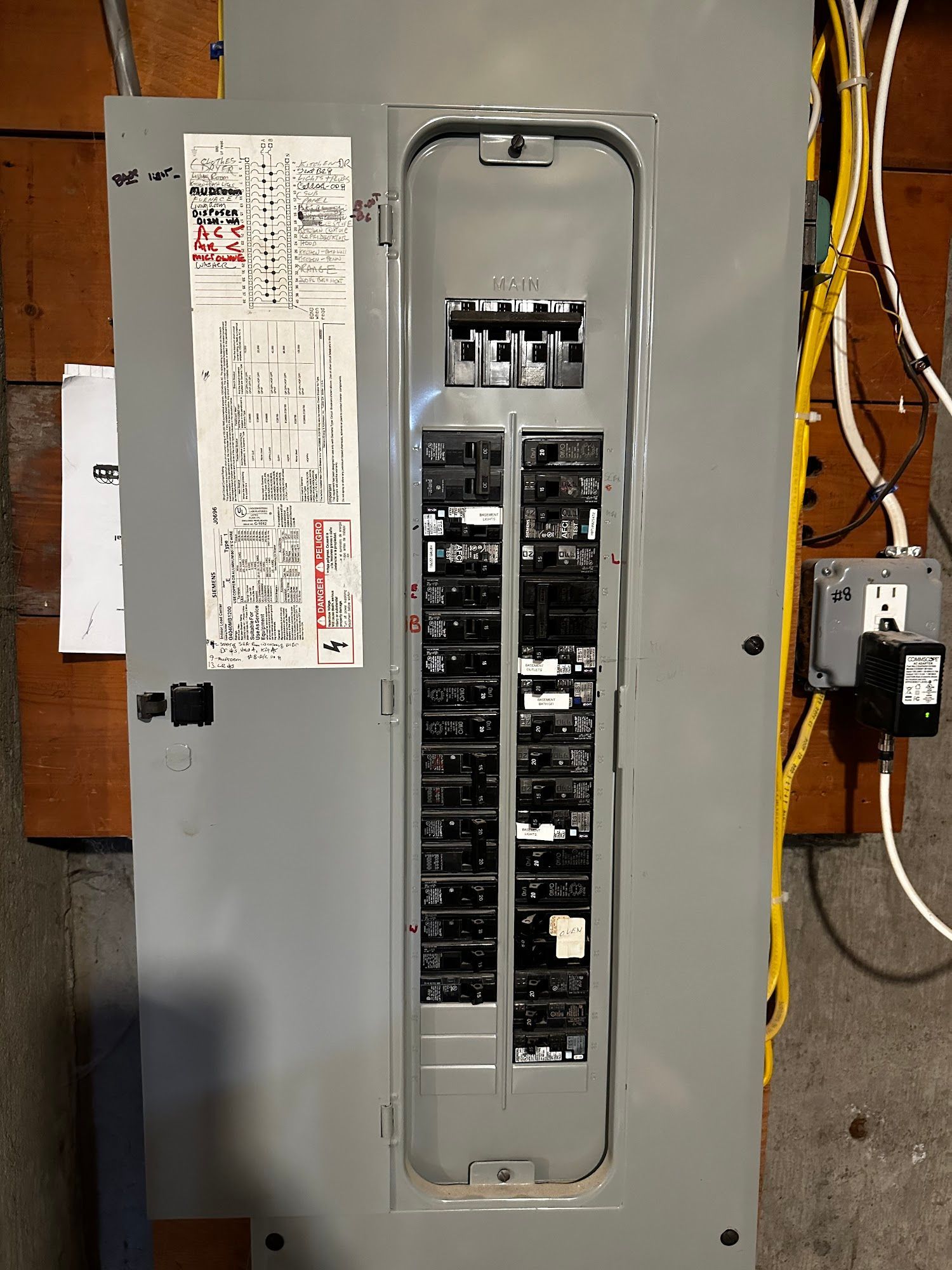 Gray electrical panel with rows of circuit breakers and a detailed wiring diagram.