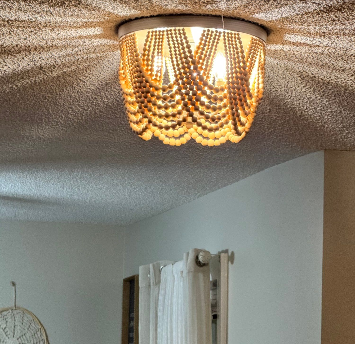 Wooden ceiling with exposed beams, wiring, and a junction box. Dark wood with visible texture.