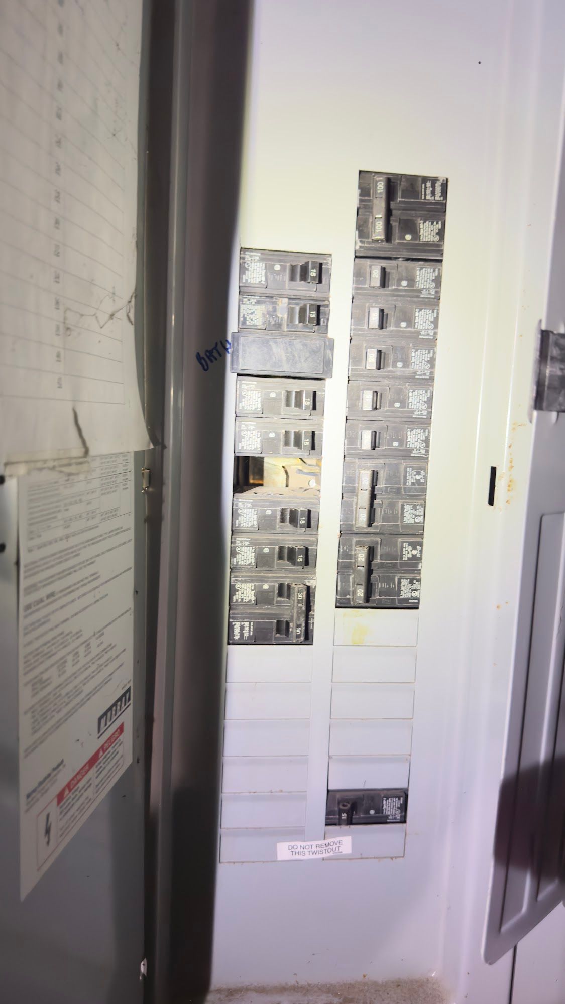 Electrical panel with circuit breakers. White panel in a utility room.