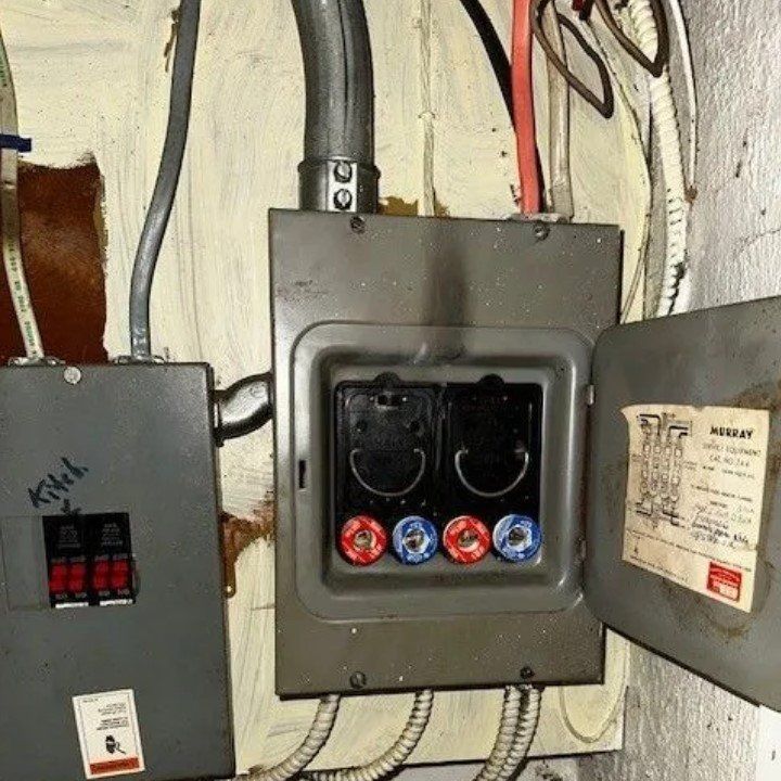 Electrical fuse box with exposed fuses and attached wiring.