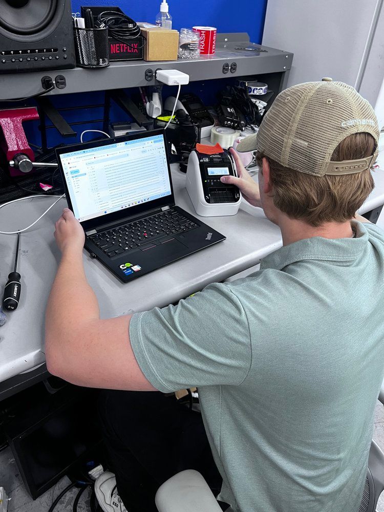 A man is sitting at a desk using a laptop computer.
