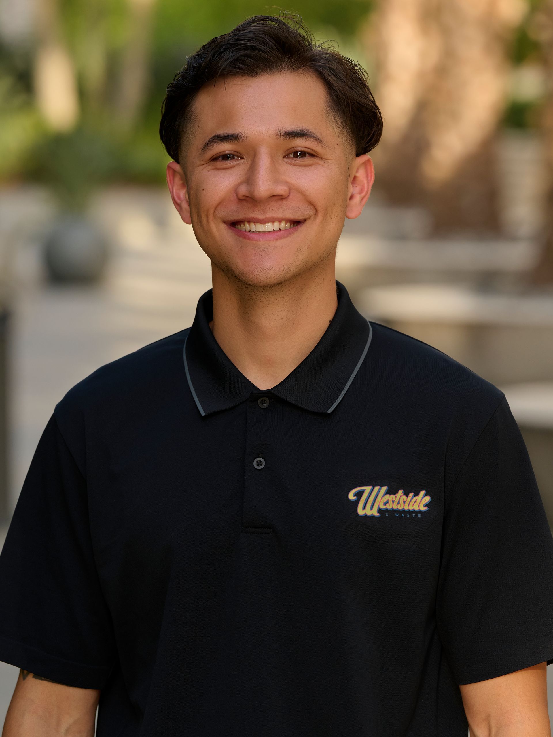 A young man in a black shirt is smiling in a circle.