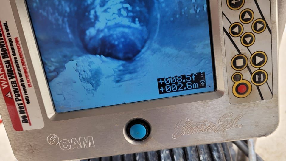 A digital sewer inspection monitor screen showing a dark, circular pipe interior at a distance of 8.5 feet.