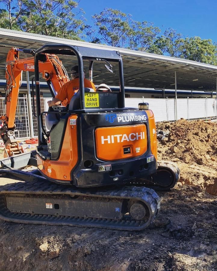 Orange Hitachi Excavator Digging in a Construction Site With a Worker in the Driver's Seat — Nambucca Plumbing in Crescent Head, NSW
