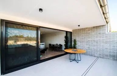 A Large Sliding Glass Door Opens to A Patio with A Table and Chairs — Nambucca Plumbing in Nambucca Heads, NSW
