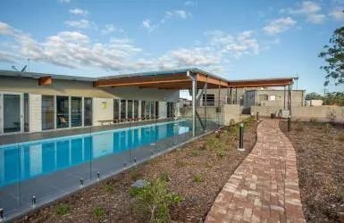 There Is a Large Swimming Pool in The Backyard of A House — Nambucca Plumbing in Nambucca Heads, NSW