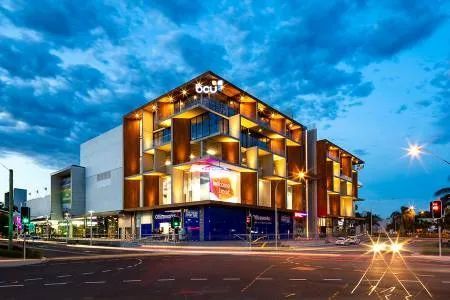 A Large Building with A Lot of Windows Is Lit up At Night — Nambucca Plumbing in Nambucca Heads, NSW