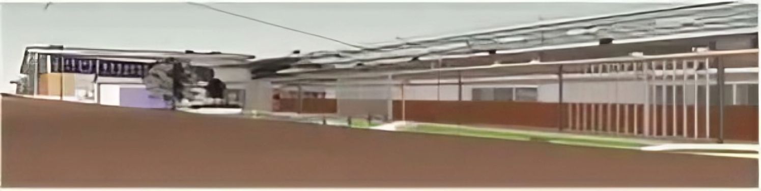 A Blurry Picture of A Building with A Fence in Front of It — Nambucca Plumbing in Nambucca Heads, NSW