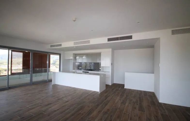 A Large Empty Room with A Kitchen and A Large Island in The Middle — Nambucca Plumbing in Nambucca Heads, NSW