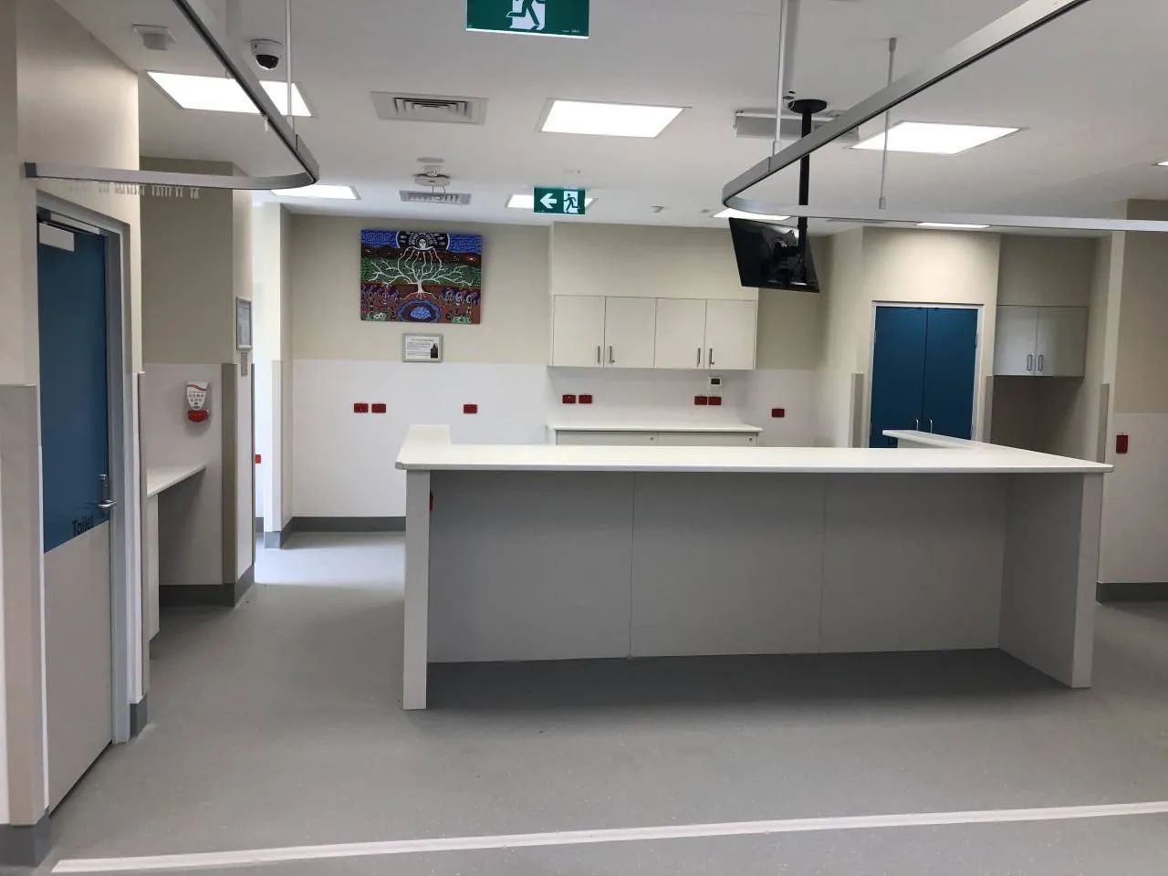 An Empty Hospital Room with A Green Exit Sign on The Ceiling — Nambucca Plumbing in Nambucca Heads, NSW