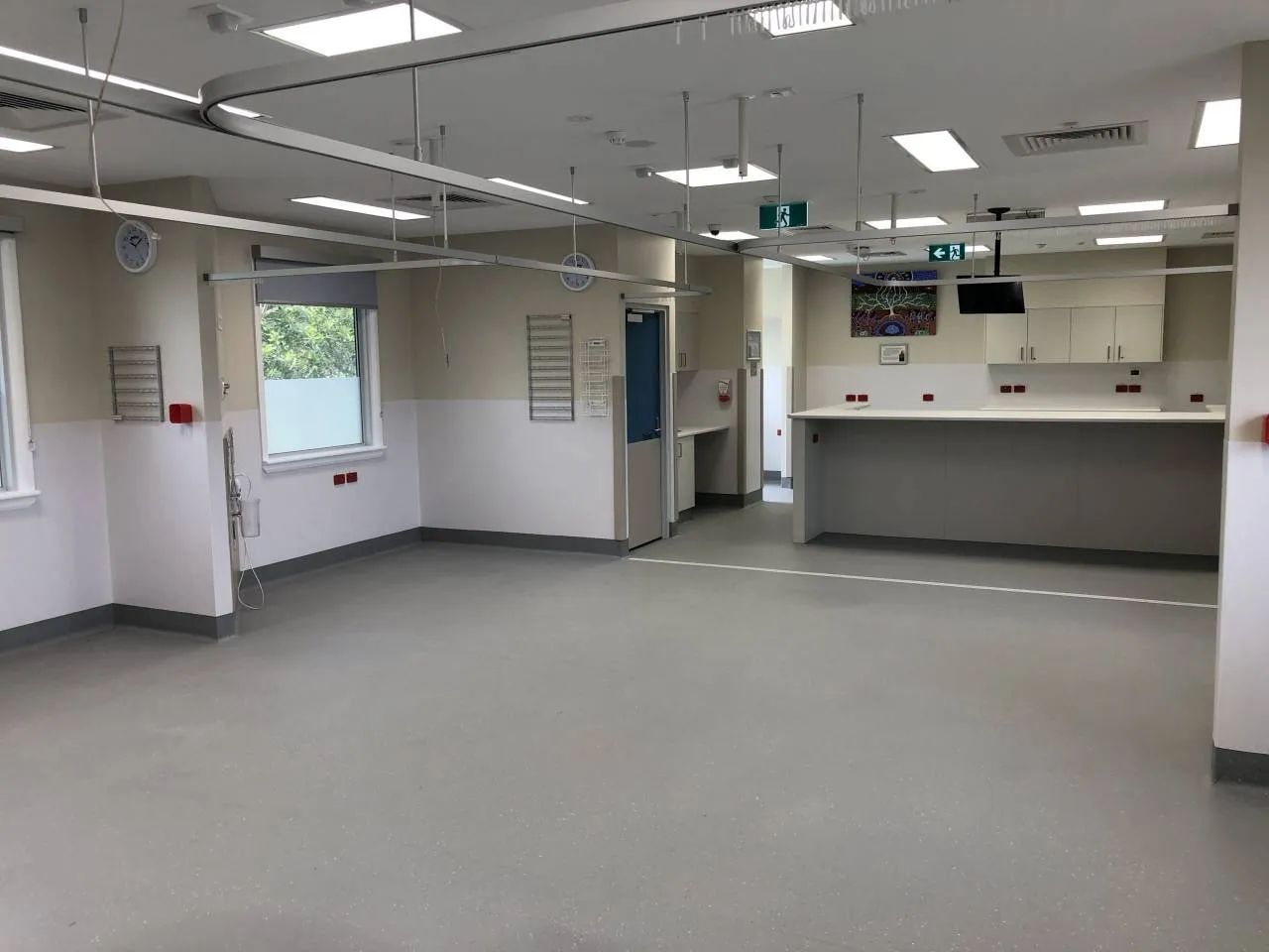 A Large Empty Room in A Hospital with A Counter and A Window — Nambucca Plumbing in Nambucca Heads, NSW
