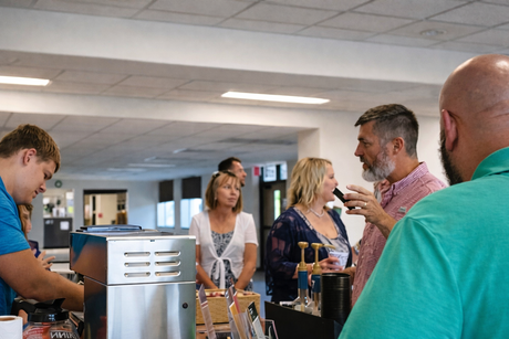 People chatting around a cafe counter in a bright fellowship hall