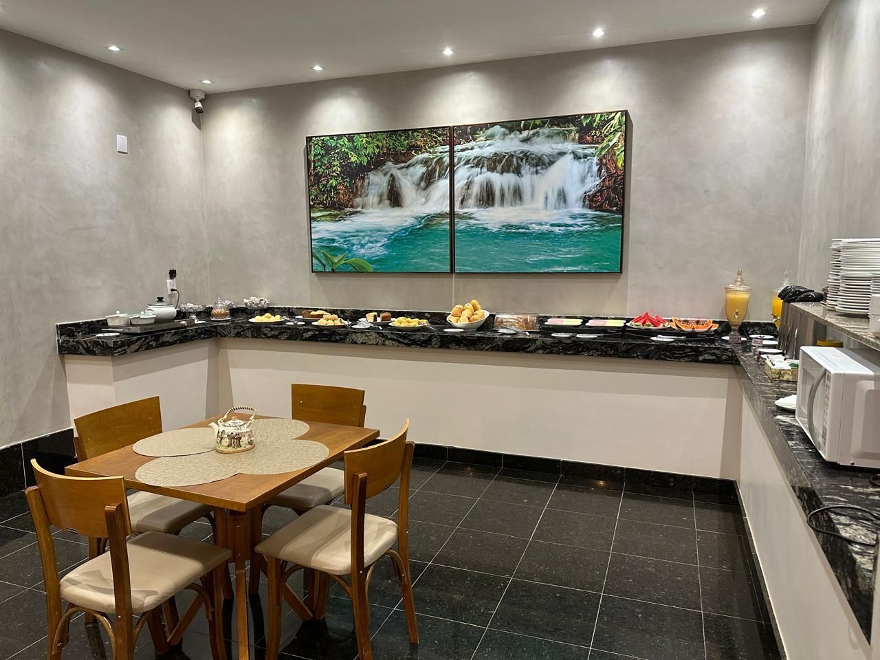 Área de buffet de café da manhã com alimentos dispostos em um balcão