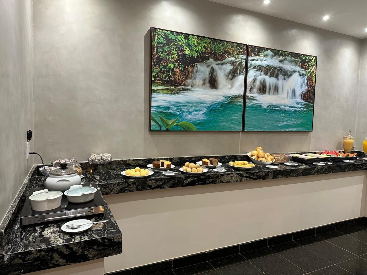 Buffet de café da manhã com diversas opções de comida dispostas em um balcão