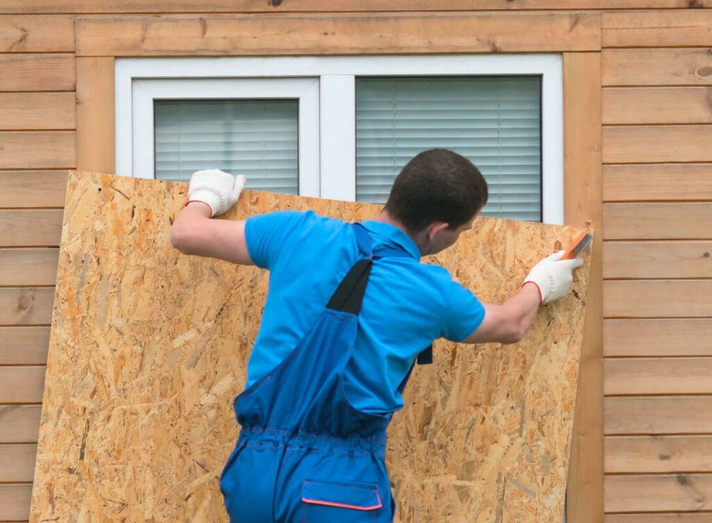 A man is looking out of a skylight on a roof.