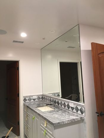 A bathroom with a large mirror and a sink.