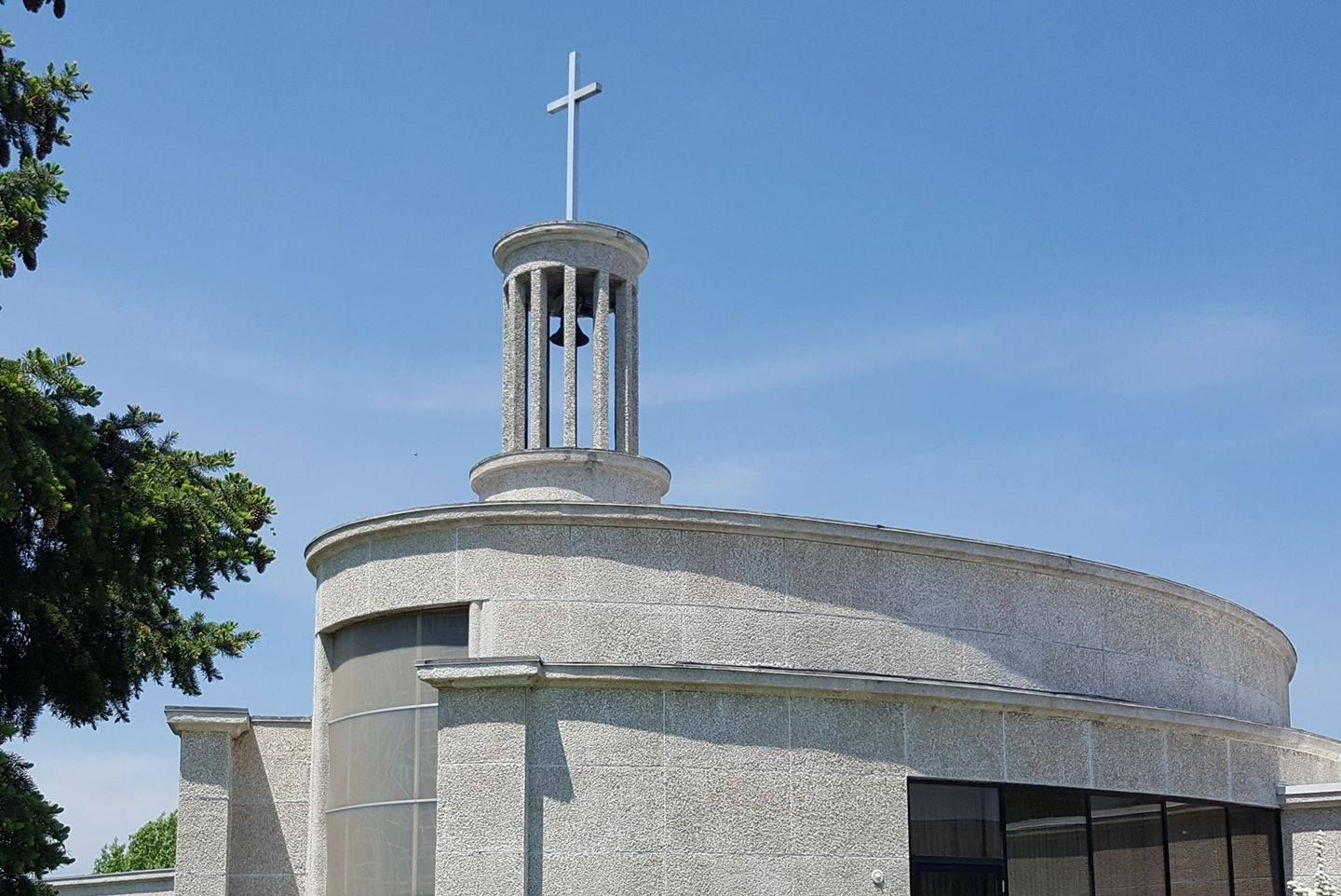 A church with a bell tower and a cross on top of it.