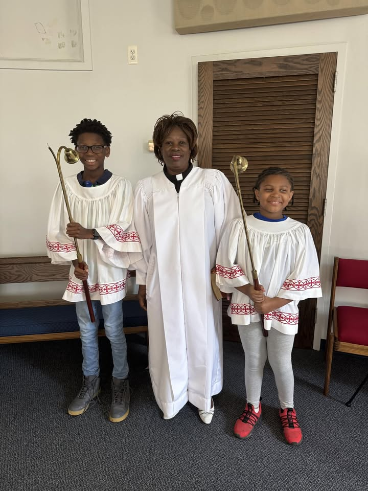 A woman and two children are standing next to each other in a church.