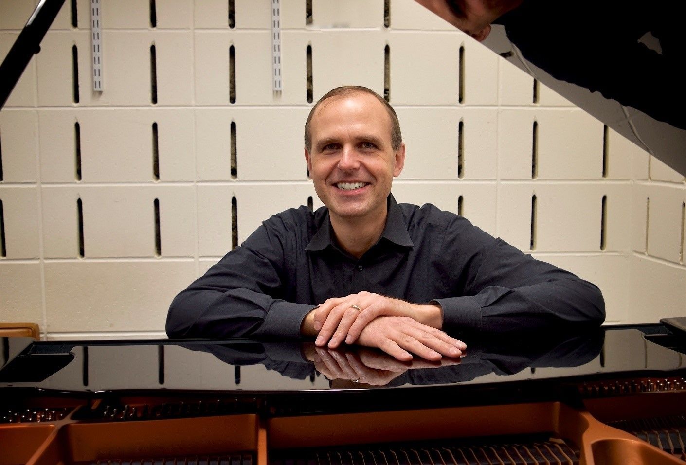 A man sitting at a piano with his hands on the keyboard